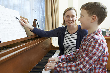 钢琴室音乐老师上钢琴课的男孩背景