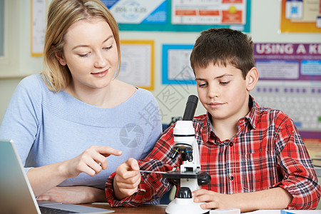 科学课用显微镜的男学生老师图片