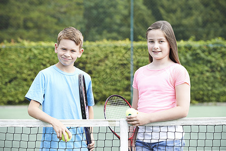 男孩女孩打网球的肖像图片