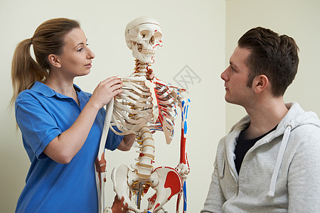骨科医生用骨骼与病人讨论损伤图片