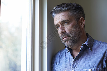 患抑郁症的成熟男人望着窗外图片