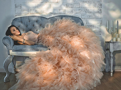 时尚的肖像美丽的女士穿着华丽的时装沙发上假日活动晚礼服公主礼服图片
