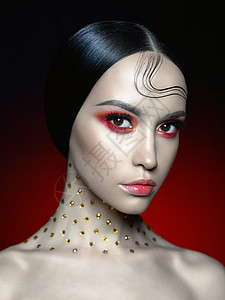 时尚工作室的美丽女人肖像与鲜红的化妆时尚美丽完美的妆容图片