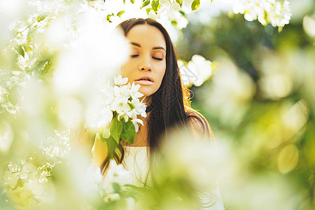 户外时尚照片,美丽的轻女人被苹果树的花包围春天开花了图片