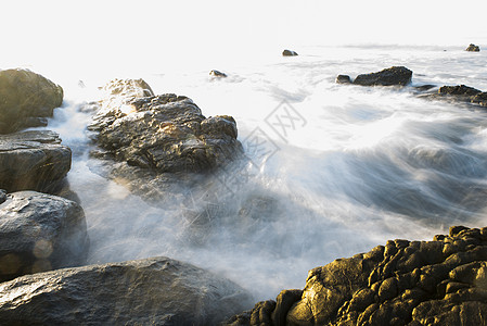 缓慢的速度捕捉流入岩石池的海潮图片