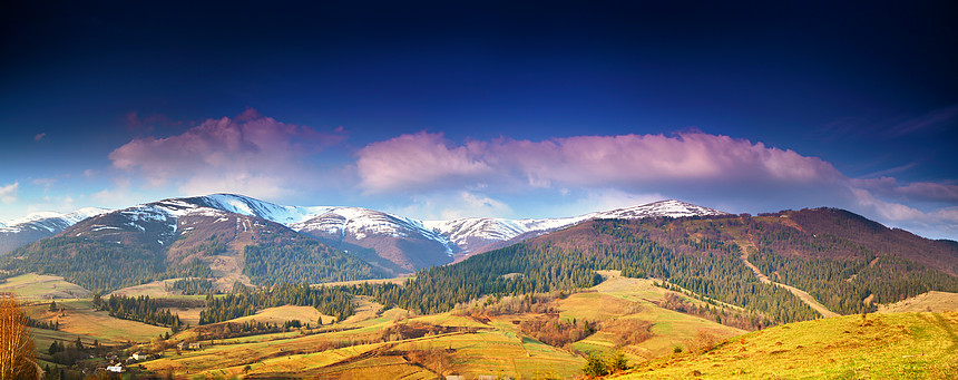春季雪山全景晨光中的山脉深蓝色的天空田园诗般的春天,高山晨景,背景中新鲜的绿色草地白雪皑皑的山顶图片