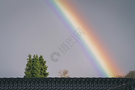 雨后,城市的屋顶上五颜六色的彩虹图片
