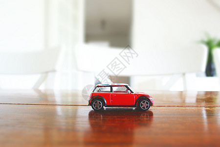 红色玩具车明亮的室内环境中的木制桌子上图片