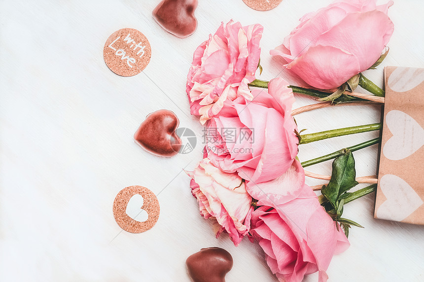 爱的贺卡与粉红色玫瑰,巧克力与心符号文字与爱白色木制背景,顶部视图图片