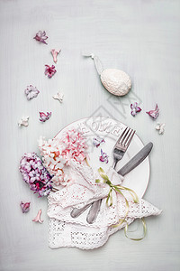 复活节餐桌装饰鸡蛋,盘子,餐具,餐巾,丝带美丽的粉彩淡风信子花,顶部的景观成图片