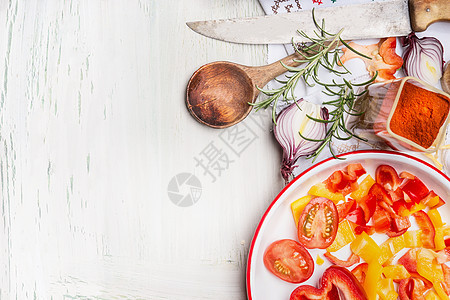 切蔬菜,调味品草药与烹饪木勺菜刀白色木制背景,顶部视图,边界健康素食饮食营养图片