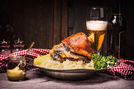 捷克啤酒烤猪肉节Eisbein与土豆泥,红烧酸菜,啤酒芥末乡村厨房桌子上的深色木制背景,正视图猪腿好了,德国食物背景
