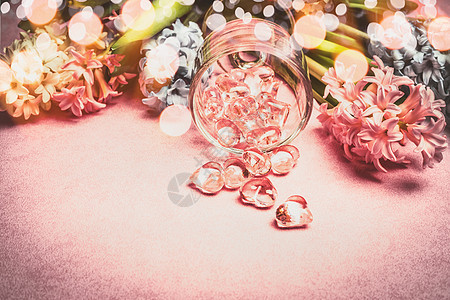 春天的花朵与波基璃心装饰粉红色的背景上图片