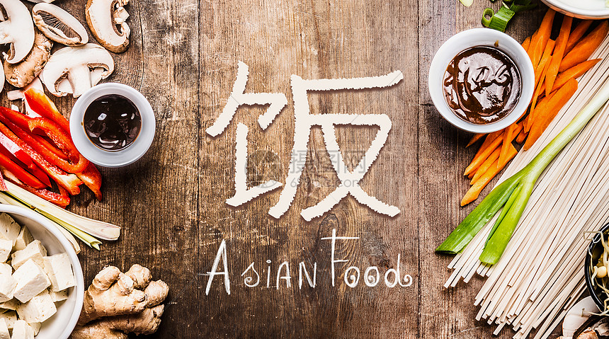 亚洲食品与各种蔬菜烹饪原料木制背景与中国象形文字的食物顶部视图