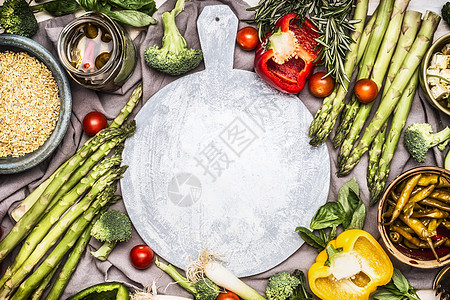 各种健康素食成分与珍珠大麦周围圆形切割板,顶部视图框架清洁饮食饮食食物的图片