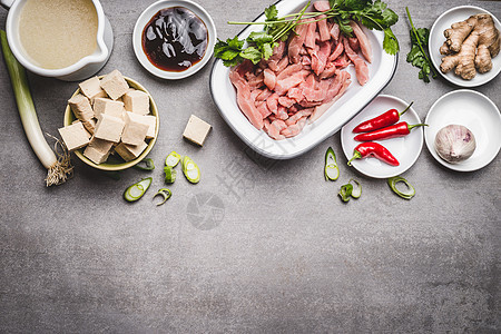 各种亚洲美食成分与豆腐肉类美味烹饪灰色石头背景,顶部视图,边界图片