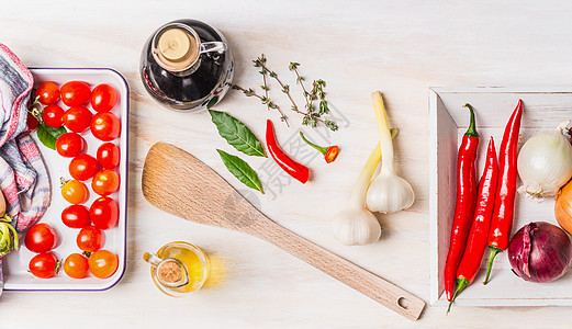 健康的烹饪与各种新鲜香料橄榄油,辣椒,洋葱,大蒜海湾叶白色木制背景,顶部视图图片
