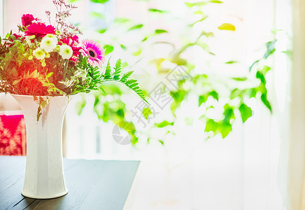 美丽的花白色花瓶桌子上的窗户背景与绿叶,室内图片