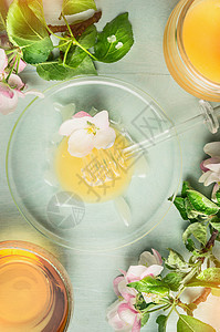 轻蜂蜜与北斗七星璃板,罐子杯茶与春天盛开的乡村木制背景,顶部视图,图片