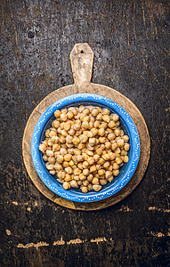 小鸡豌豆,鹰嘴豆蓝色碗与水乡村木背景,顶部的背景图片