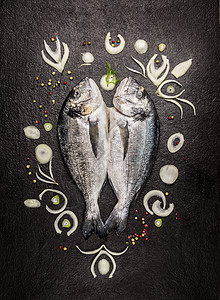两条生的全多拉多鱼,黑暗的背景上香料图案,顶部的景色图片