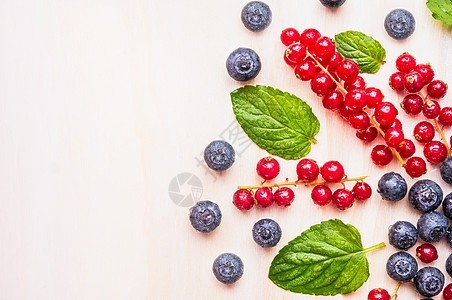 红色醋栗,蓝莓黑莓与水滴薄荷叶白色木制背景,顶部视图,文字的地方图片