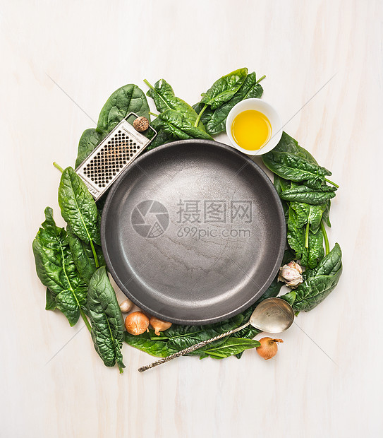 新鲜菠菜叶与烹饪原料油,肉豆蔻,大蒜橄榄周围的个空灰色的盘子白色的木制背景,顶部的视图,文字的地方图片