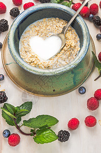 燕麦片与牛奶夏季浆果背景的心脏形状图片