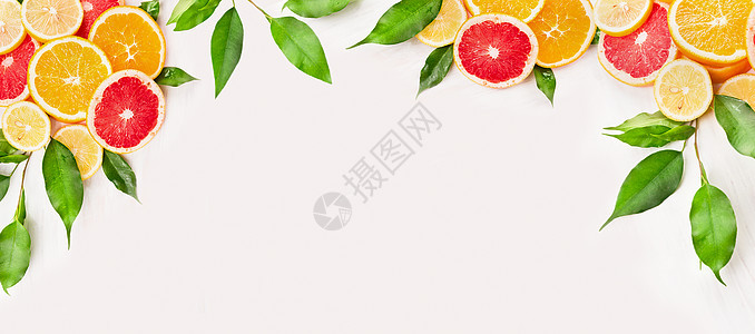 柑橘类水果切片与绿叶白色木制背景,为网站图片