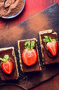 提拉米苏蛋糕与草莓片石板上,顶部视图图片