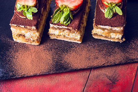 提拉米苏蛋糕黑色石板红色木制背景上图片