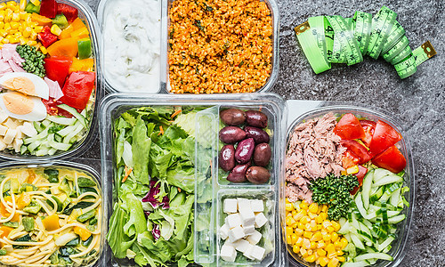 各种健康饮食饭盒与蔬菜沙拉测量磁带沙拉碗塑料包装与测量磁带,顶部视图节食带走食物图片