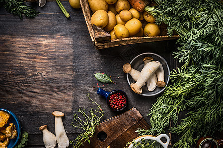 秋季季节烹饪配料与收获蔬菜,绿色,土豆蘑菇黑暗的乡村厨房桌子背景,顶部视图,地点为文本,边界图片