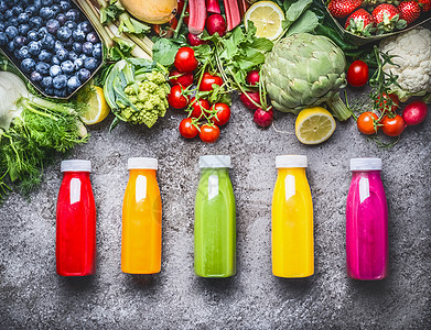 健康的红色,橙色,绿色,黄色粉红色的冰沙果汁灰色混凝土背景与新鲜的机蔬菜,水果浆果成分,顶部视图图片