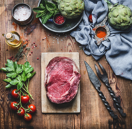 生鲜肉牛排与配料烧烤烹饪乡村木制背景,顶部视图图片