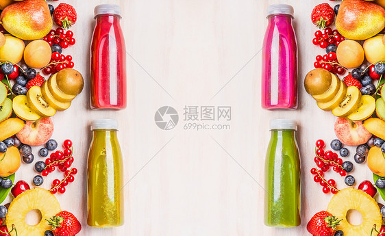 红色,粉红色,绿色黄色冰沙果汁饮料瓶与各种新鲜机水果浆果成分白色木制背景,顶部视图健康食品的图片