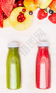 美味健康的夏季饮料瓶与水果浆果成分红色绿色冰沙果汁白色木制背景,顶部视图图片