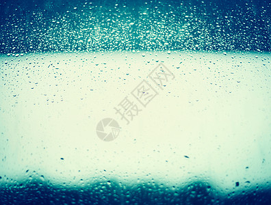 蓝色窗户璃背景上的雨滴图片
