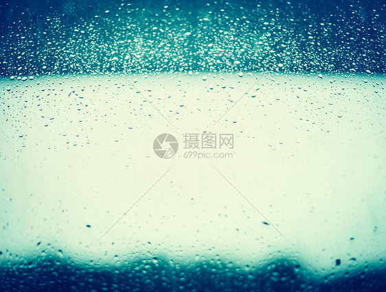 蓝色窗户璃背景上的雨滴图片