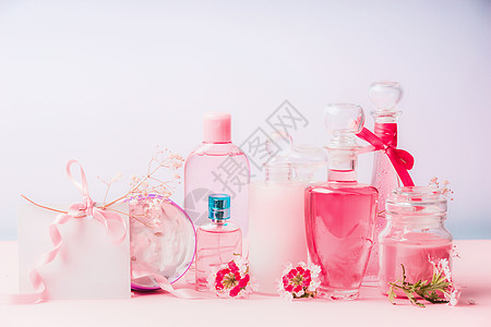 香水背景各种天然化妆品瓶罐子与粉红色的花粉彩背景,正视图美容护肤的背景,正观点背景