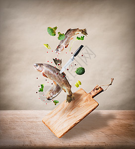 飞生的整条鳟鱼,蔬菜油香料成分,米色背景的桌子厨房桌子上进行美味的烹饪健康食品饮食饮食图片