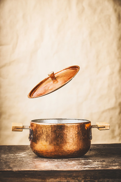 铜锅与飞开盖子木制厨房桌子墙壁背景,正视图图片