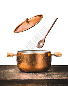 铜锅与飞开盖子木制勺子桌子上,隔离白色背景,正视图图片
