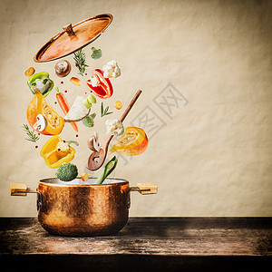 健康的素食饮食烹饪与各种飞斩蔬菜成分,烹饪锅勺子木制桌子自然背景,正视图清洁食品的图片