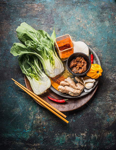 亚洲烹饪配料与巴基斯坦菜,生姜,香料,辣椒筷子木制菜肴为中国泰国菜黑暗的乡村背景,顶部的图片