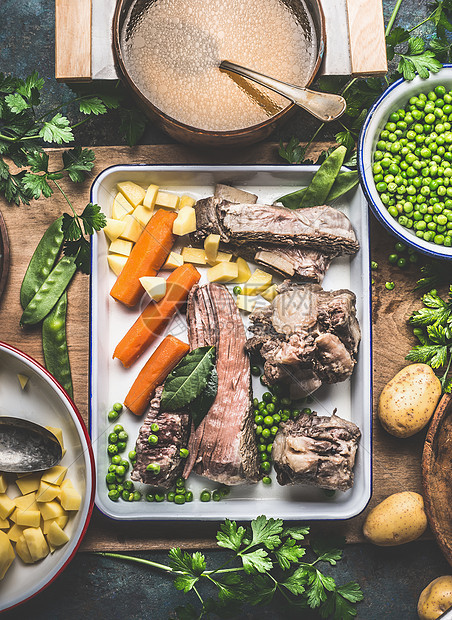 汤烹饪准备与锅肉汤,熟肉,蔬菜,土豆青豌豆乡村厨房桌子上,顶部视图图片