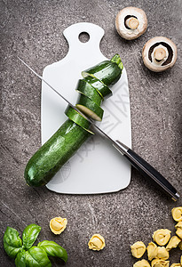绿色切片西葫芦白色切割板与菜刀,顶部视图健康素食烹饪饮食,饮食图片