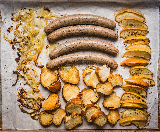 烤盘上的油炸香肠,烤苹果,洋葱碱液包,顶部视图,德国食物图片