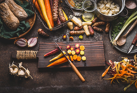 五颜六色的胡萝卜切片与刀木制切割板上的乡村餐桌背景与根蔬菜成分,美味的素食烹饪,顶部视图健康的食物饮食图片