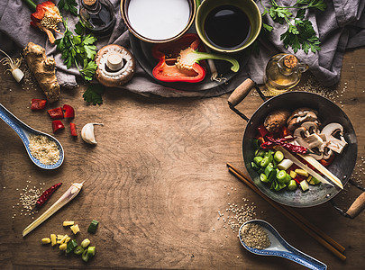 素食炒菜准备木制背景与各种蔬菜,炒锅,椰奶,种子厨房用具,顶部视图,框架亚洲菜健康的饮食饮食观念图片